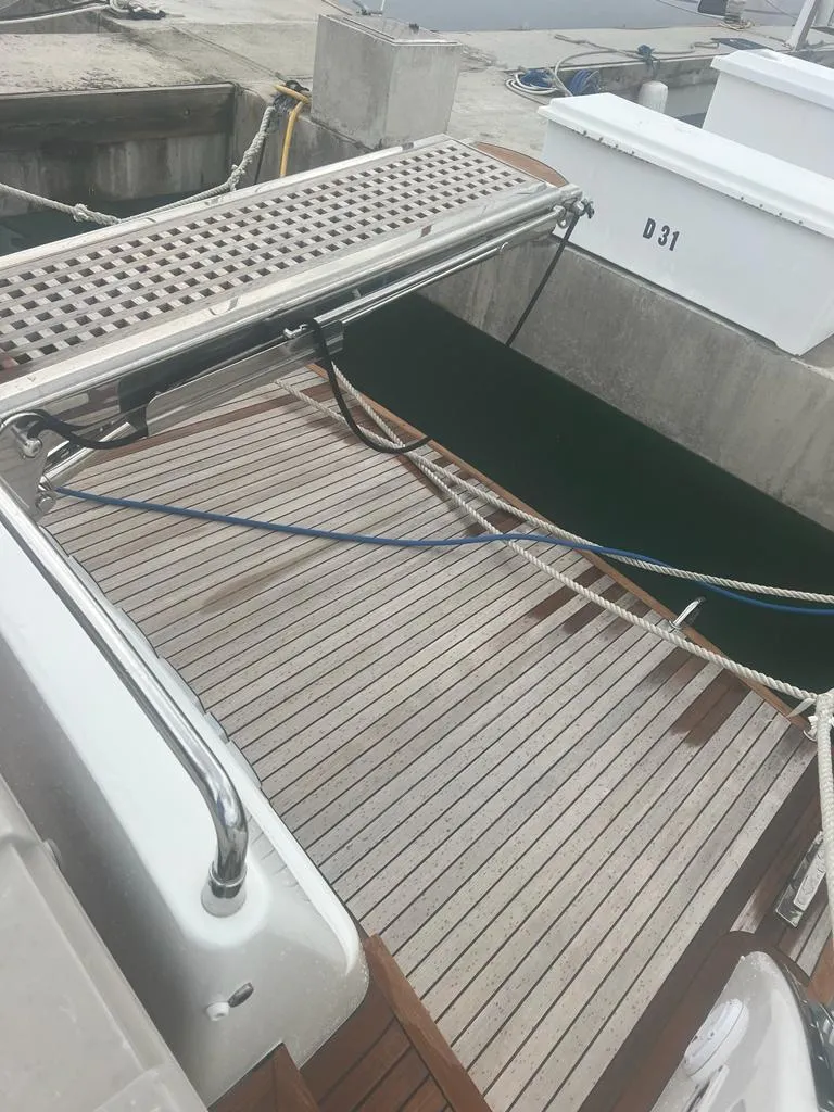 Slide: The Image of 2007 Uniesse 54 Sport yacht stern with wooden deck at marina. - 23