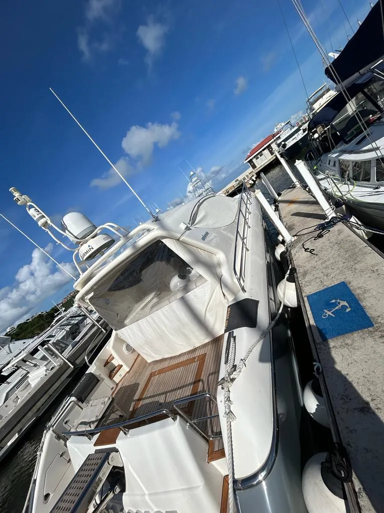 Slide: The Image of Alt text: 2007 Uniesse 54 Sport yacht docked at marina under clear blue sky. - 6
