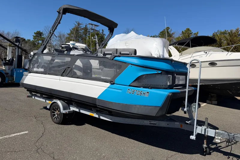 The Image of 2023 Sea-Doo Switch Cruise 21 on trailer, parked outdoors, featuring blue and white design. - 0