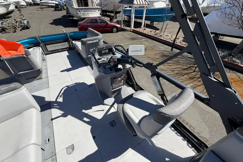 Slide: The Image of 2023 Sea-Doo Switch Cruise 21 interior with steering console and seating, parked outdoors. - 11