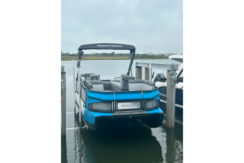 Slide: The Image of 2023 Sea-Doo Switch Cruise 21 pontoon boat docked on a calm lake. - 19