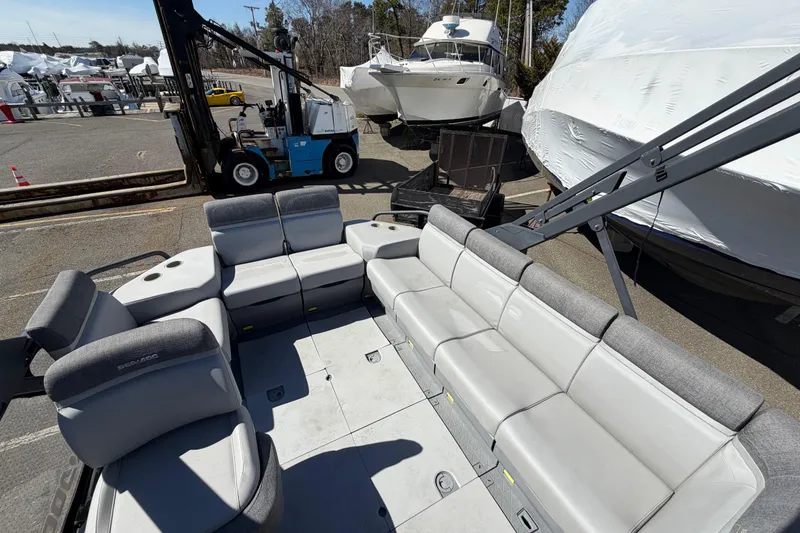 Slide: The Image of 2023 Sea-Doo Switch Cruise 21 pontoon boat with spacious seating at a marina. - 9