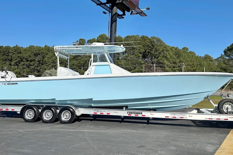 The Image of 2025 Contender 39 ST boat on trailer, light blue hull, parked outdoors. - 10