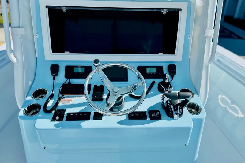 Slide: The Image of 2025 Contender 39 ST boat console with steering wheel, controls, and communication devices. - 11