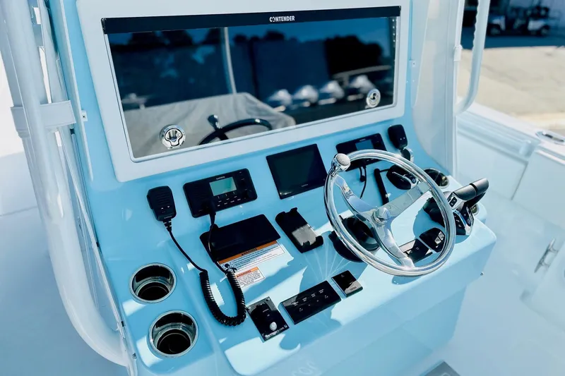 Slide: The Image of 2025 Contender 39 ST boat dashboard with steering wheel and control panel. - 13