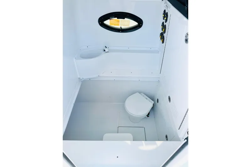 Slide: The Image of 2025 Contender 39 ST boat interior with compact marine toilet and control panel. - 19
