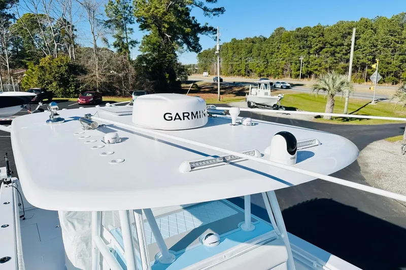 Slide: The Image of 2025 Contender 39 ST boat with Garmin radar, surrounded by trees and parked cars. - 23