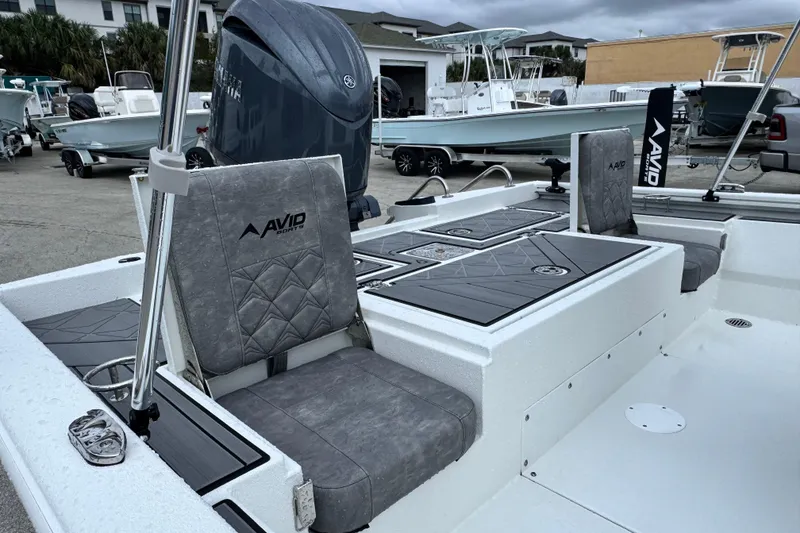 Slide: The Image of 2026 Avid 23 Fusion boat interior with gray seating and Yamaha outboard motor. - 13