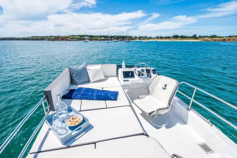Slide: The Image of 2026 Beneteau Antares 11 yacht deck with seating, ocean view, and clear blue skies. - 23
