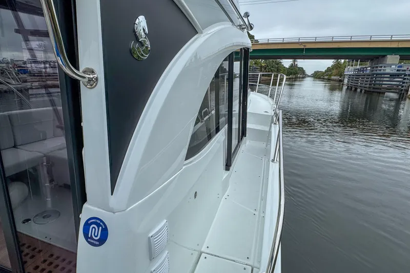 Slide: The Image of 2026 Beneteau Antares 11 boat deck with seating and open hatch, on water. - 32