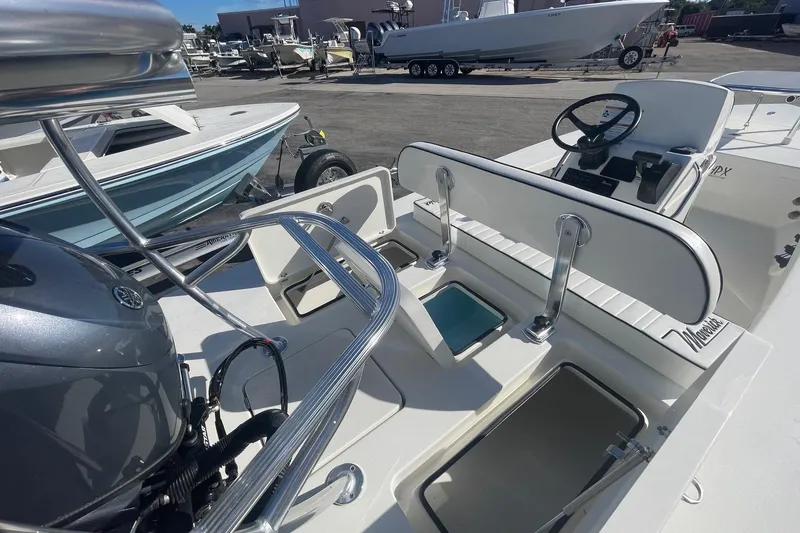 Slide: The Image of 2026 Maverick HPX-17 V boat interior with seating and steering wheel, parked in a marina. - 8