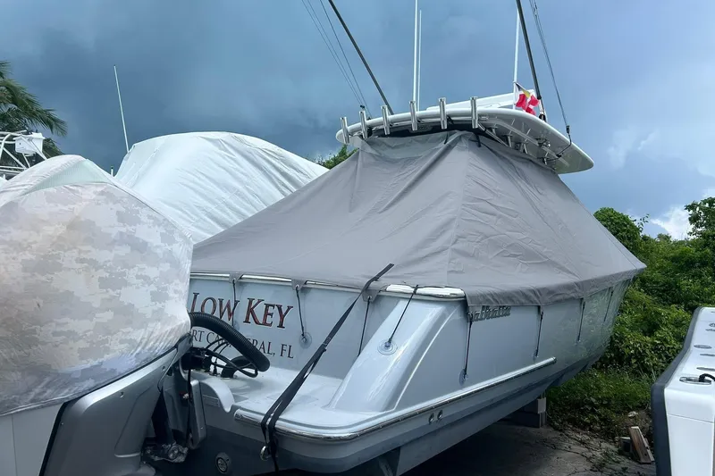 Slide: The Image of 2021 Valhalla V-33 boat covered, parked outdoors, with stormy sky background. - 18