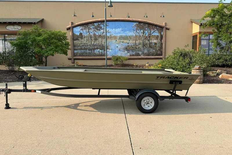 The Image of 2026 Tracker Grizzly 1754 Utility boat on trailer, outdoor setting with mural background. - 0