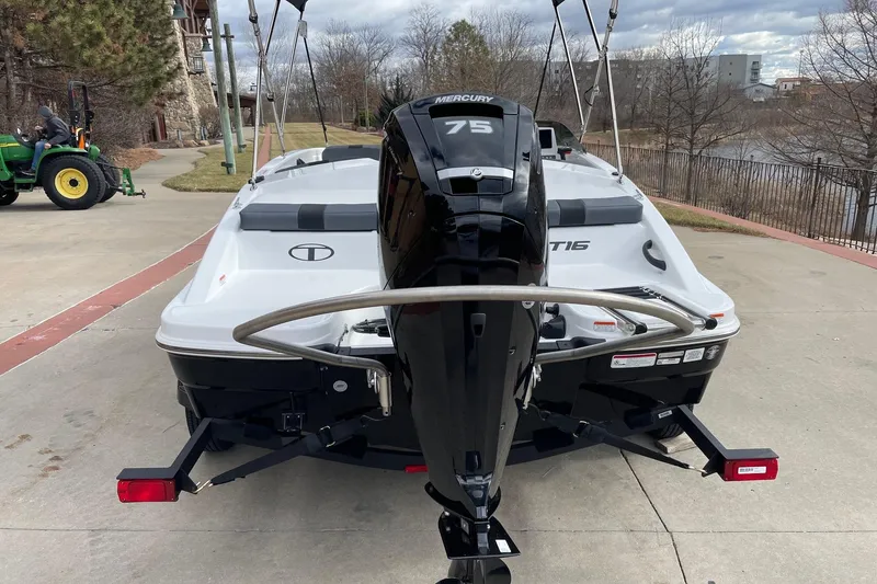 Slide: The Image of 2026 Tahoe T16 boat with Mercury 75 engine, parked on a concrete driveway. - 2
