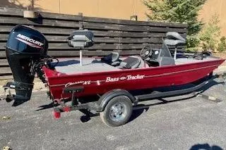 Slide: The Image of 2026 Tracker Bass Tracker Classic XL boat with Mercury engine, parked outdoors. - 2