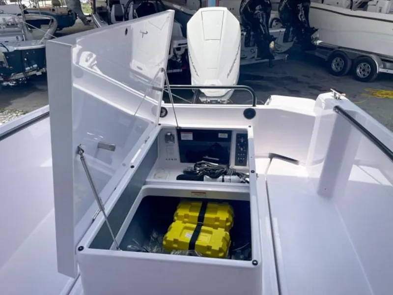 Slide: The Image of 2024 Axopar 25 Cross Top boat storage compartment with equipment and yellow case. - 19