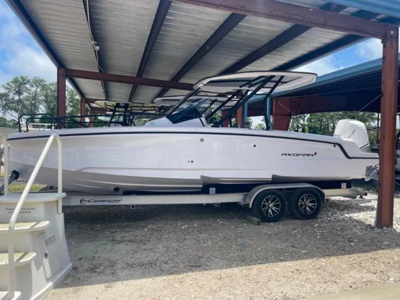 Slide: The Image of 2024 Axopar 25 Cross Top boat on trailer under metal shelter. - 3