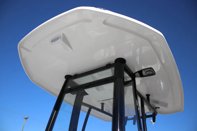 Slide: The Image of Tidewater 2210 Carolina Bay 2026 boat T-top against clear blue sky. - 13