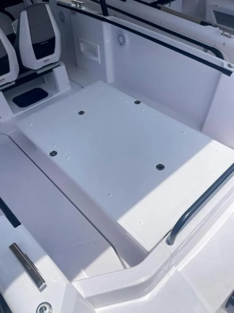 Slide: The Image of 2024 Axopar 25 Cross Top boat interior with seating and storage area. - 17