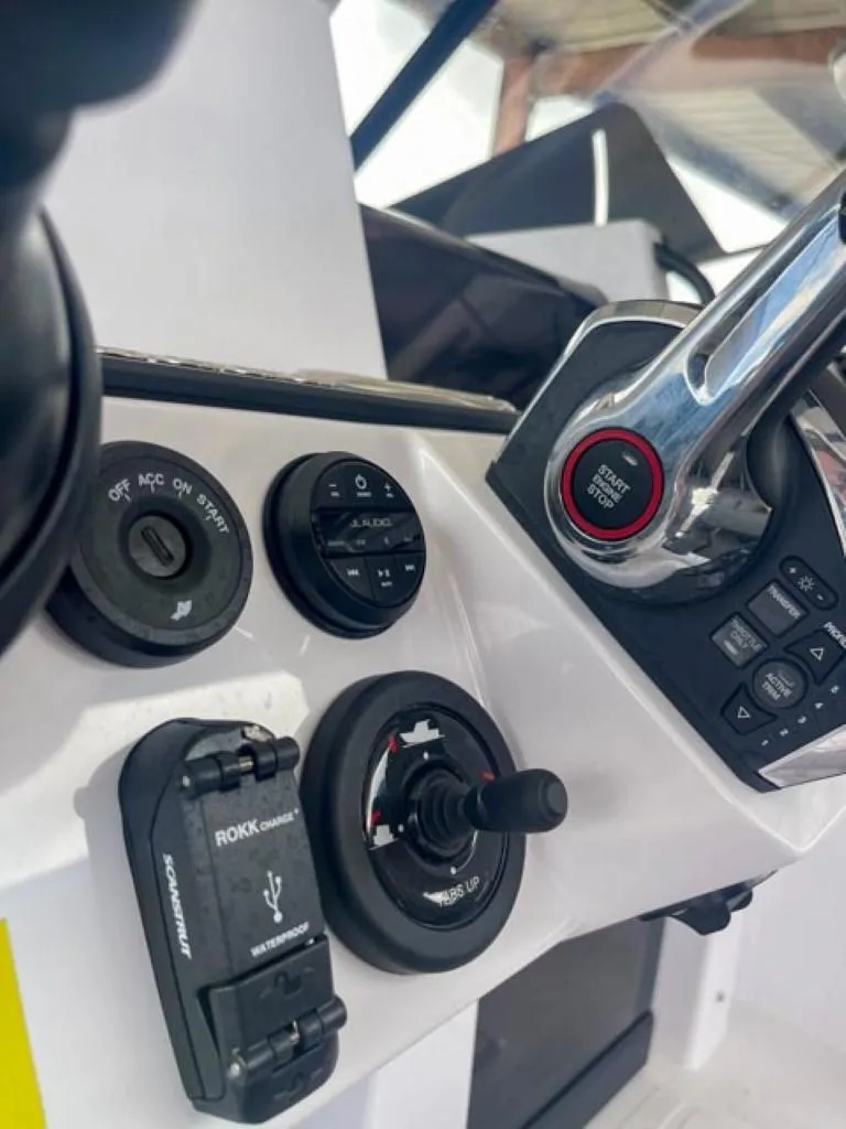 Slide: The Image of 2024 Axopar 25 Cross Top boat dashboard with controls and USB port. - 8