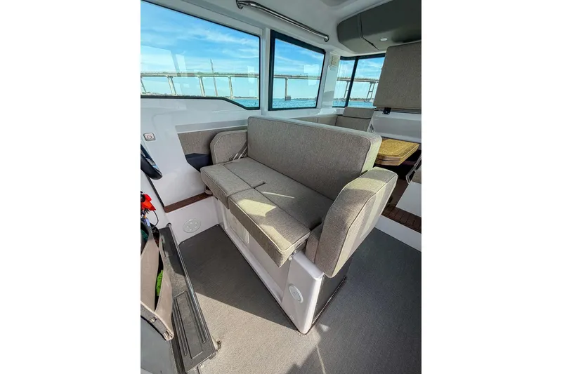 Slide: The Image of 2023 Axopar 37 XC Cross Cabin interior with gray seating and large windows. - 14