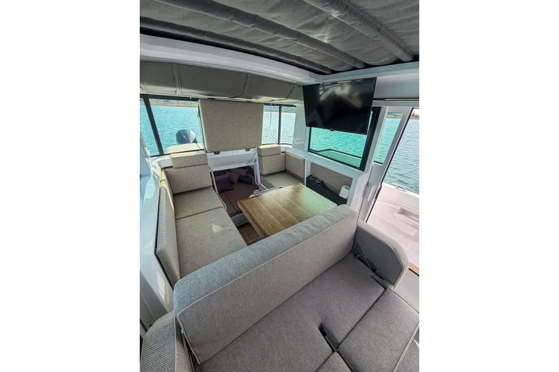 Slide: The Image of Interior of 2023 Axopar 37 XC Cross Cabin with seating, table, and TV. - 15