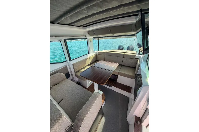 Slide: The Image of Interior of 2023 Axopar 37 XC Cross Cabin with seating and table, overlooking water. - 16