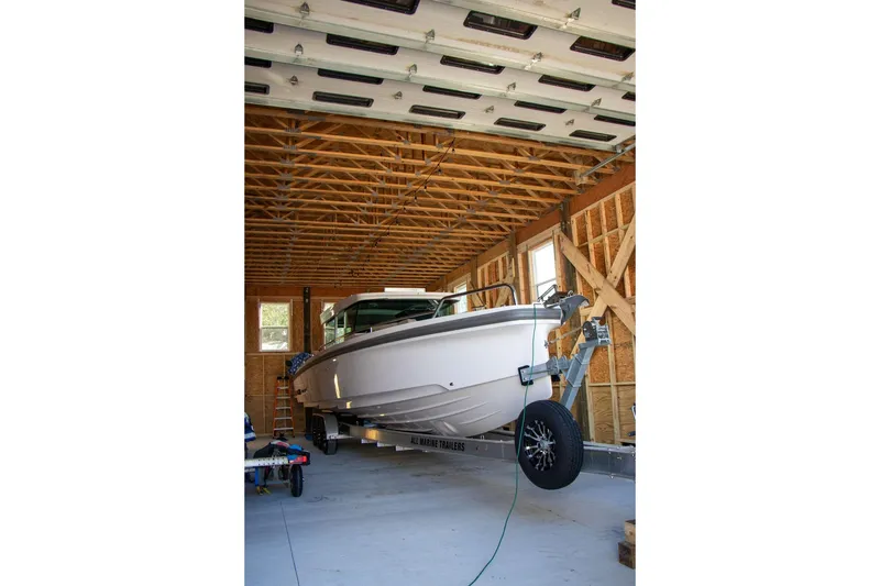 Slide: The Image of 2023 Axopar 37 XC Cross Cabin boat in a wooden garage on a trailer. - 20