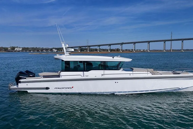 Slide: The Image of 2023 Axopar 37 XC Cross Cabin boat cruising on a sunny day near a bridge. - 5