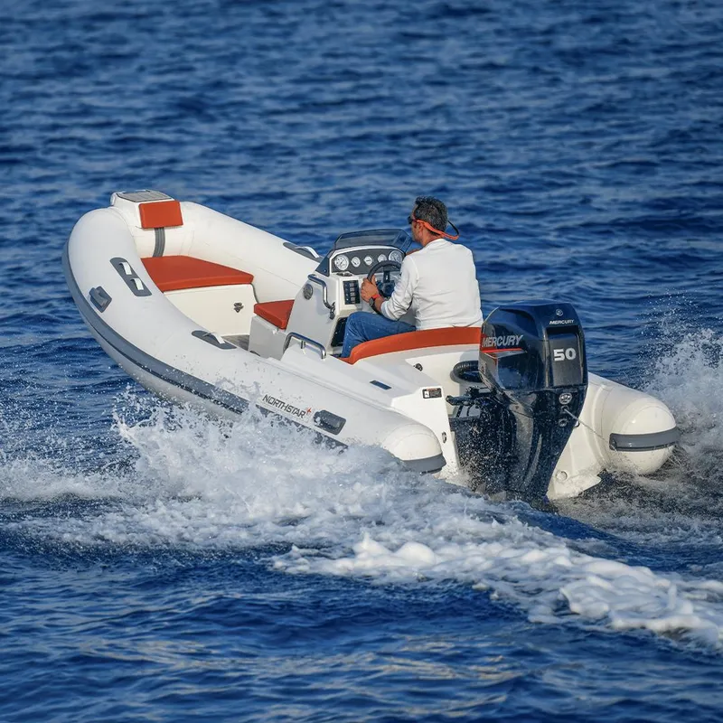 Slide: The Image of 2023 Northstar Axis 4.2 boat cruising on open water with Mercury engine. - 9