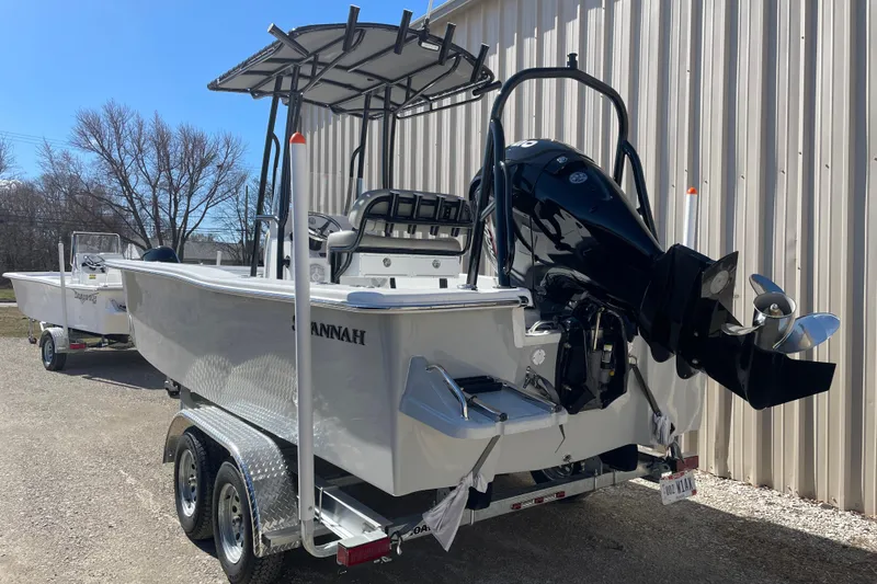 Slide: The Image of 2023 Savannah SS21 boat on trailer, parked outdoors near a building. - 13