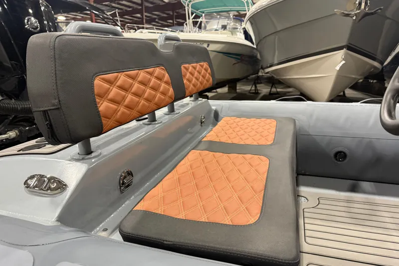 Slide: The Image of 2022 Highfield Sport 460 boat interior with quilted seats in a showroom. - 8