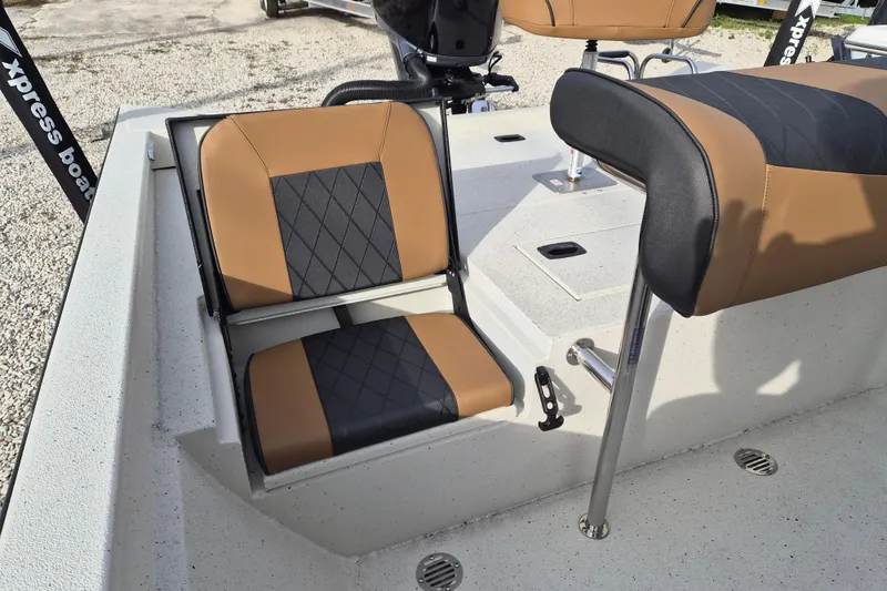 Slide: The Image of 2026 Xpress H22B Bay boat interior with tan and black seating. - 17