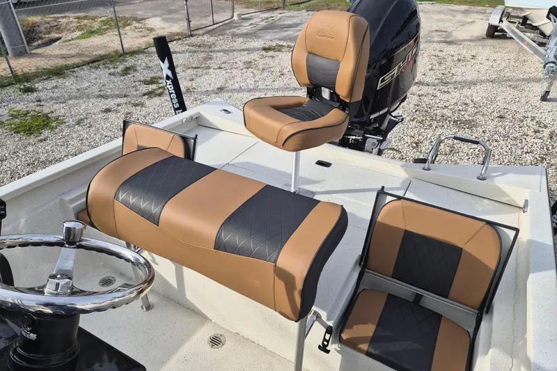 Slide: The Image of 2026 Xpress H22B Bay boat interior with tan and black seating, steering wheel, and motor. - 18