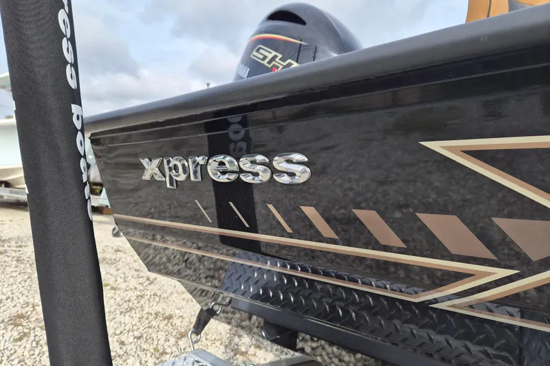 Slide: The Image of 2026 Xpress H22B Bay boat with sleek black and gold design. - 2