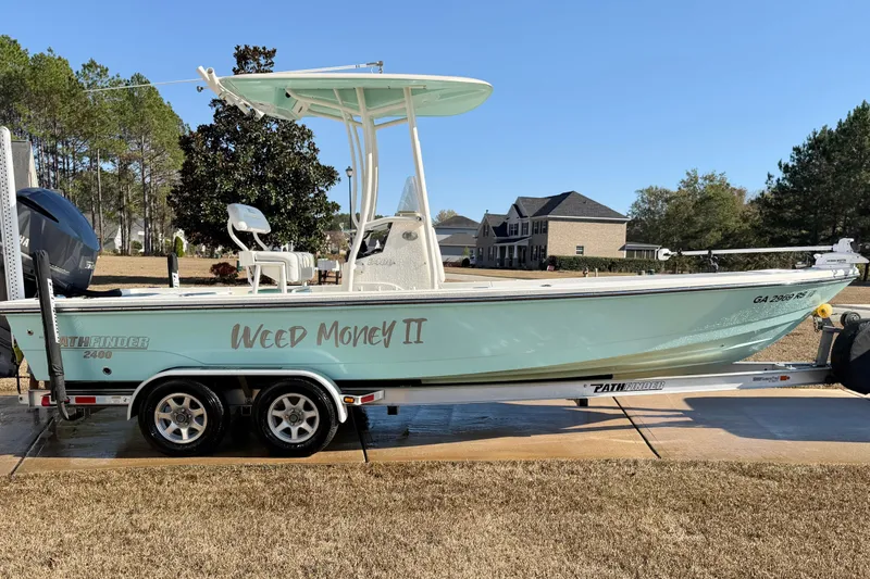 The Image of 2015 Pathfinder 2400 TRS boat on trailer, labeled "Weed Money II," parked outdoors. - 0