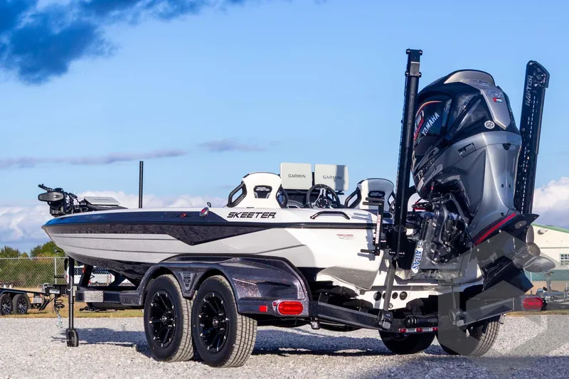 Slide: The Image of 2026 Skeeter FXR21 FLEX boat with Yamaha engine on trailer, under clear blue sky. - 10