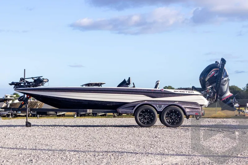 Slide: The Image of 2026 Skeeter FXR21 FLEX boat on trailer, parked outdoors under blue sky. - 11