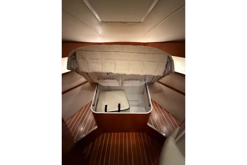 Slide: The Image of 2004 Tiara Yachts 3800 Open cabin interior with wooden flooring and storage compartment. - 57