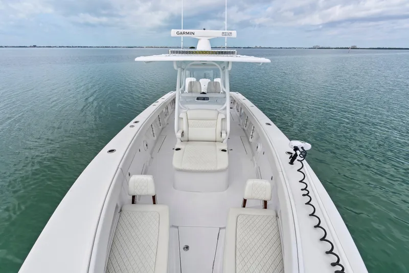 Slide: The Image of 2022 Jupiter 34 HFS boat on calm water, featuring spacious seating and advanced navigation equipment. - 12