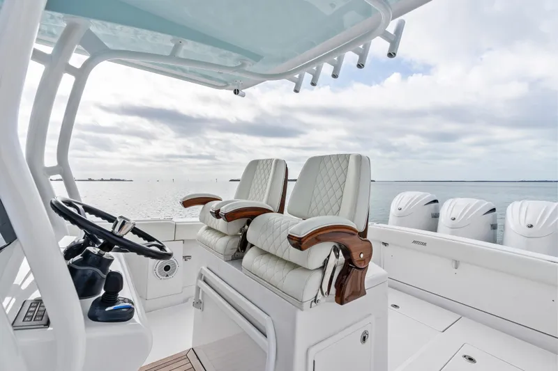 Slide: The Image of 2022 Jupiter 34 HFS boat interior with luxury seating and steering wheel, ocean view. - 14