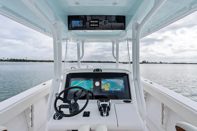Slide: The Image of 2022 Jupiter 34 HFS boat helm with dual navigation screens on calm water. - 20