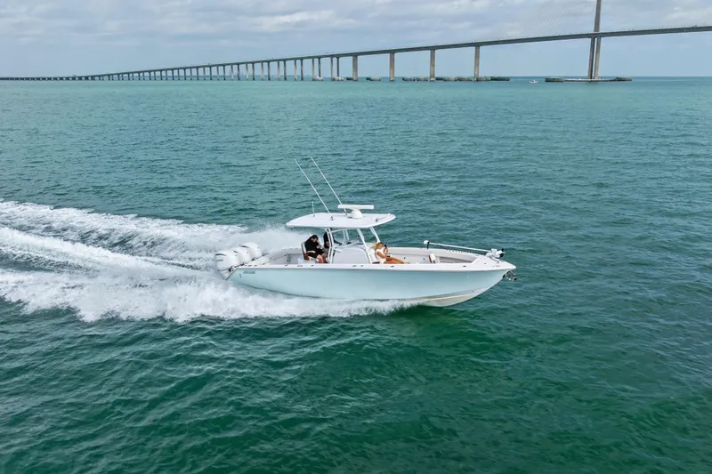 Slide: The Image of 2022 Jupiter 34 HFS boat cruising on open water near a long bridge. - 5