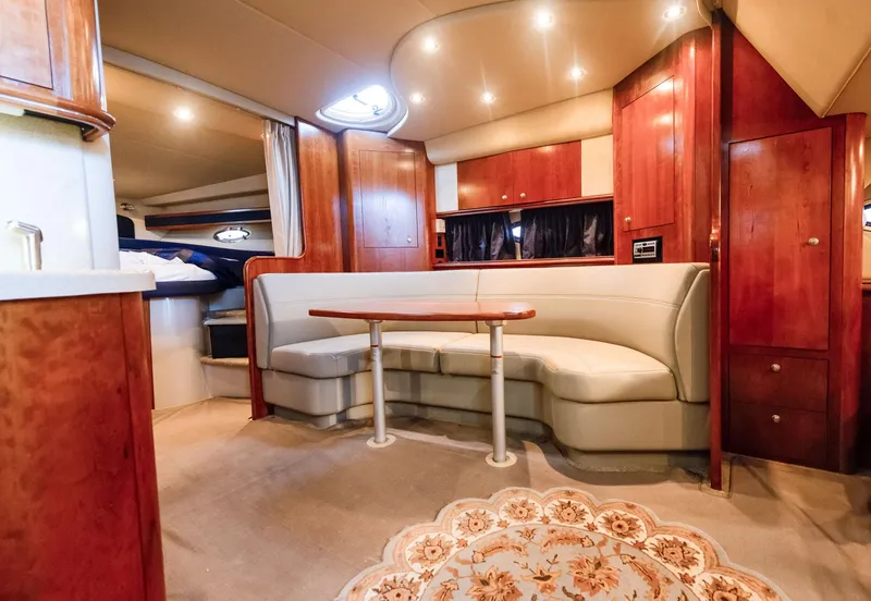 Slide: The Image of 2006 Cruisers Yachts 370 Express interior with elegant wood finish and cozy seating area. - 4