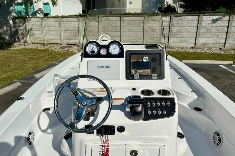 Slide: The Image of 2025 NauticStar 224 Bay boat dashboard with steering wheel and control panel. - 4
