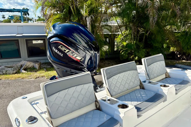 Slide: The Image of 2025 NauticStar 224 Bay boat with Yamaha engine, featuring stylish seating and lush background. - 5