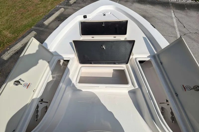 Slide: The Image of 2025 NauticStar 224 Bay boat with open storage compartments on deck. - 8