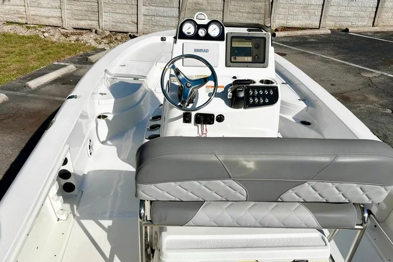 Slide: The Image of 2025 NauticStar 224 Bay boat interior with steering console and seating. - 9