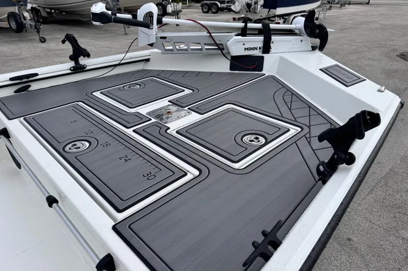 Slide: The Image of 2026 Avid 18 Rogue CC boat deck with fishing rod holders and measurement markings. - 8