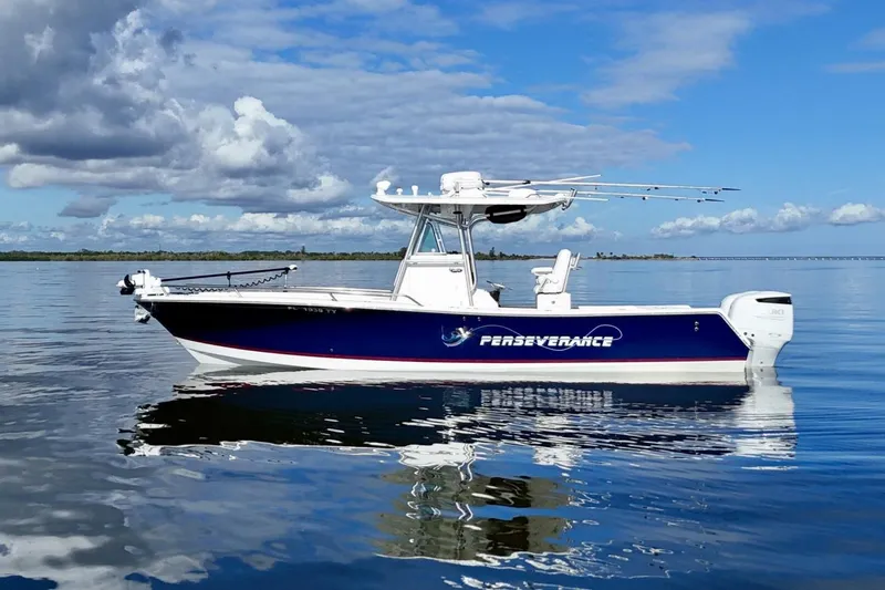 Slide: The Image of 2006 Regulator 29 Forward Seating boat on calm water under a blue sky. - 10